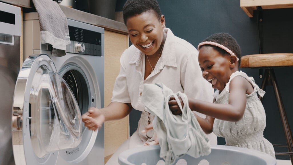 Black mother and child doing laundry.
