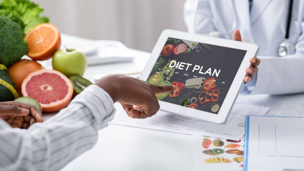 Dietitian using a tablet with patient. 