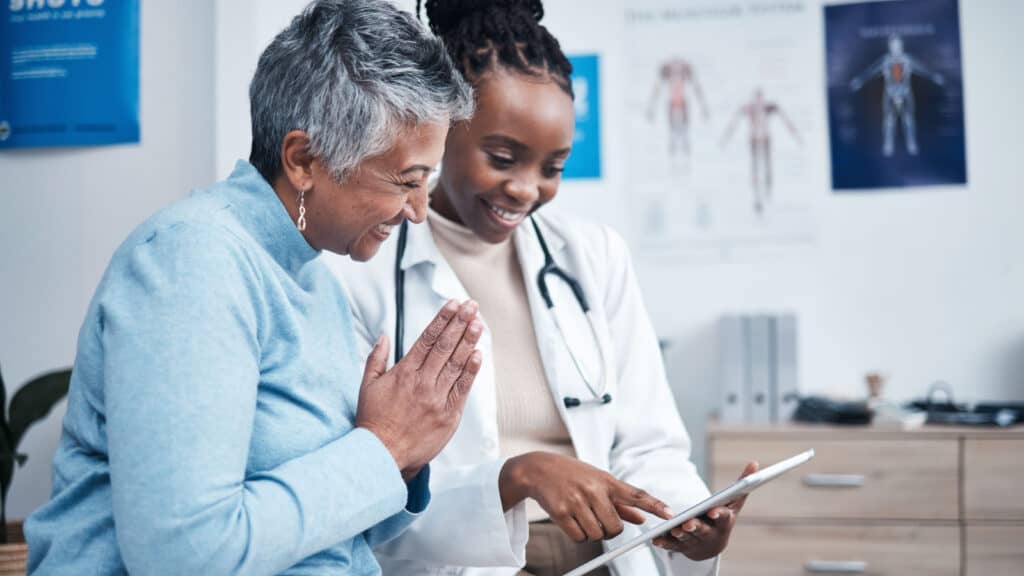 Female doctor telling female patient good news. Women of color. Black doctor.