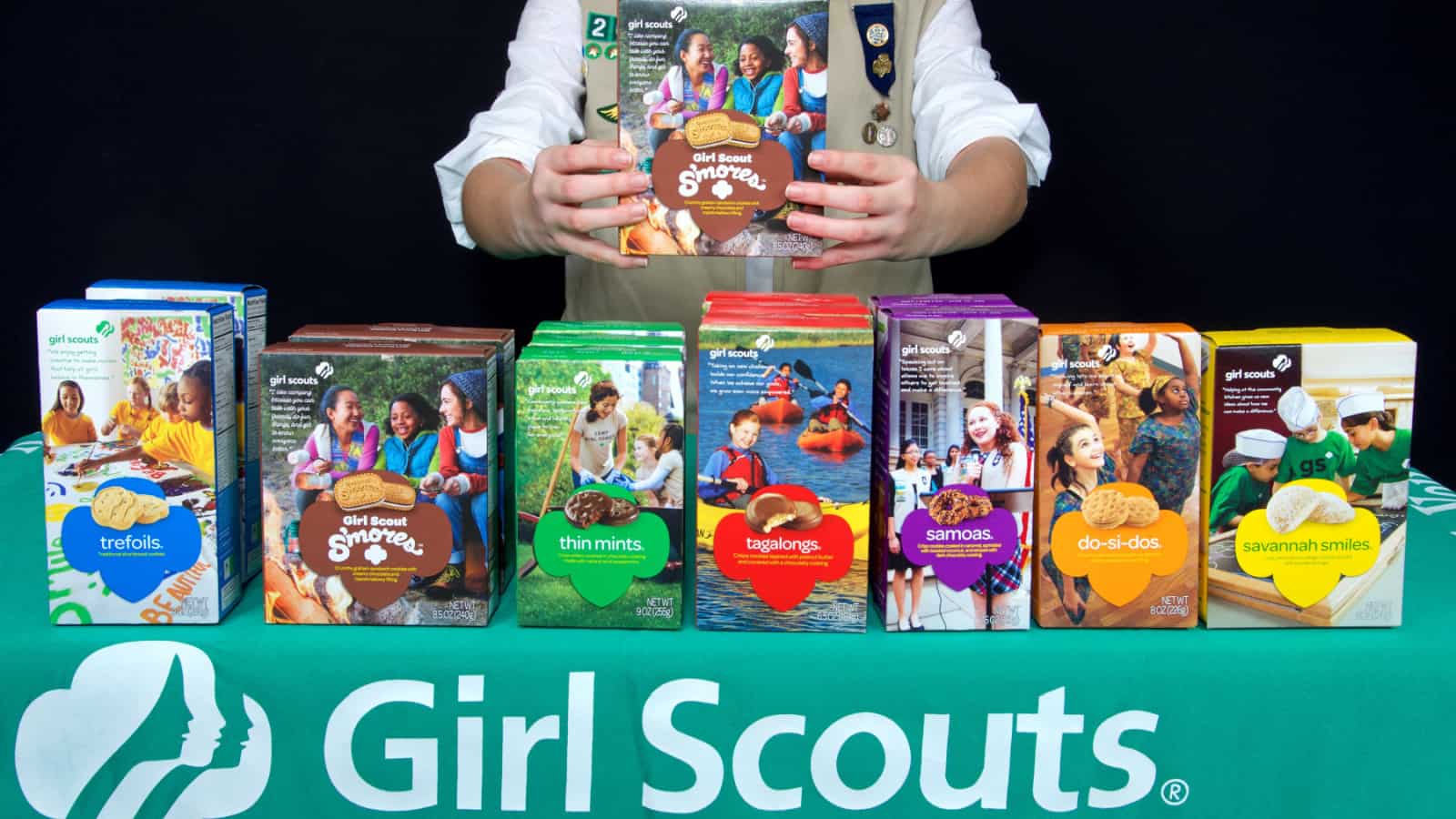 Girl Scout with boxes of cookies.
