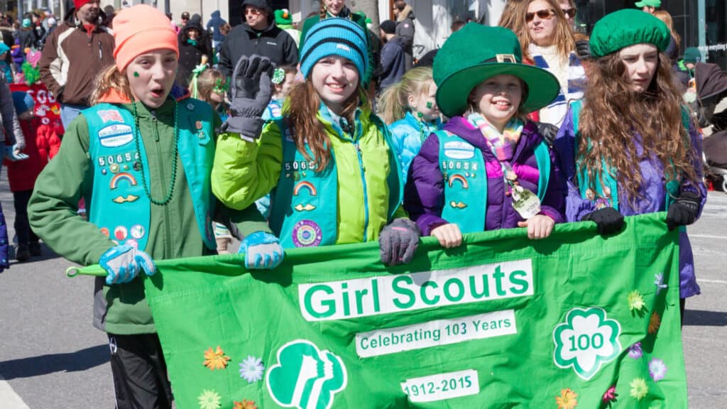 Girl scouts marching in parade. 