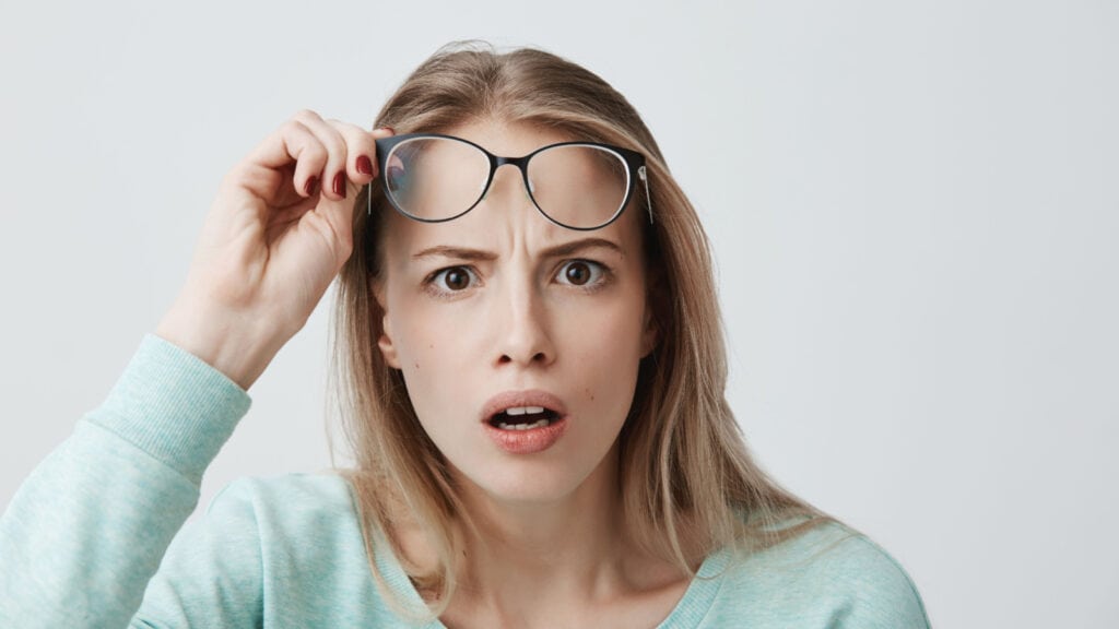 blonde woman with glasses looking shocked. Surprised. 