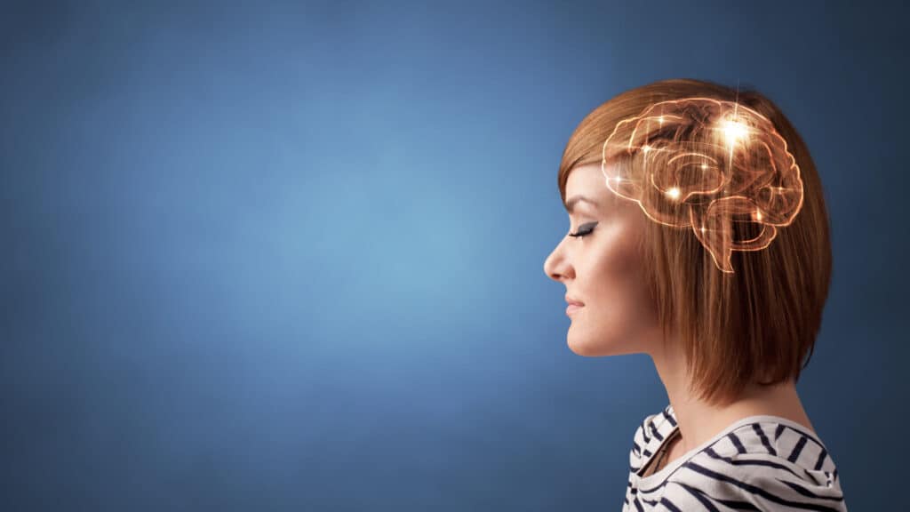 red haired woman's profile showing diagram of brain against blue background.