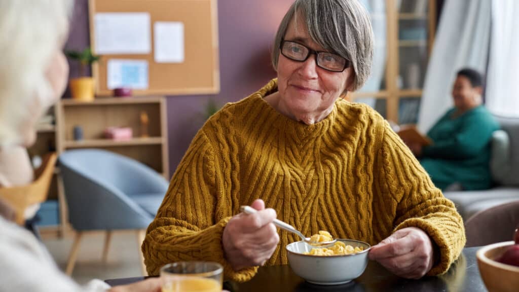 Older woman eating cereal.