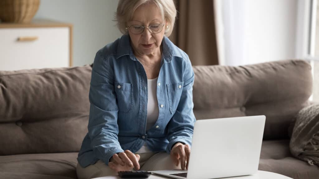 Senior woman using calculator.