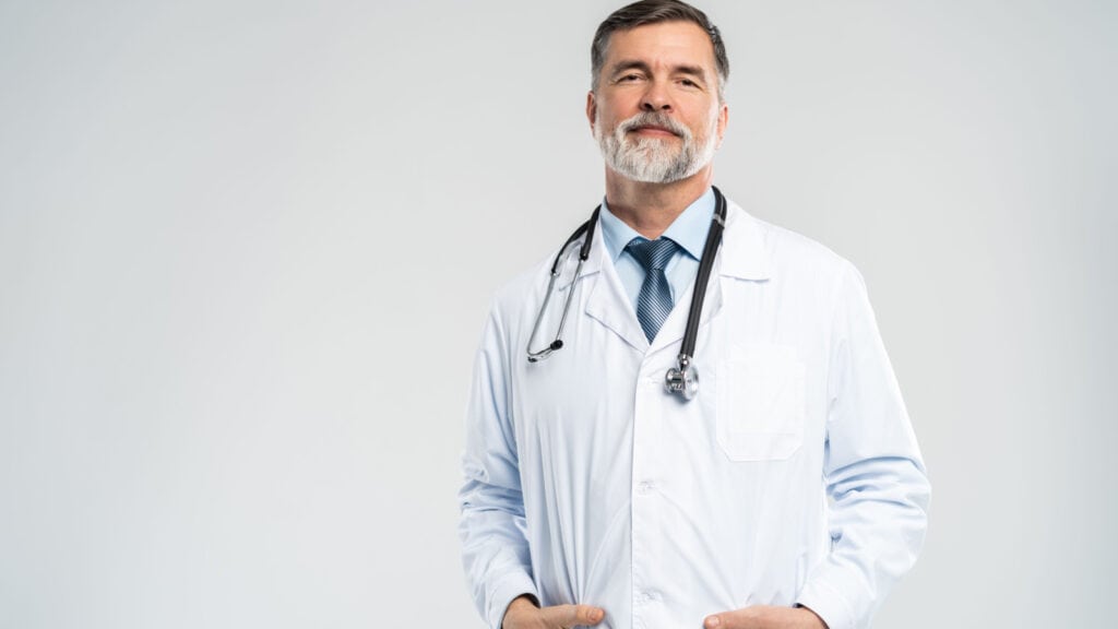 White male doctor with beard in white coat. 