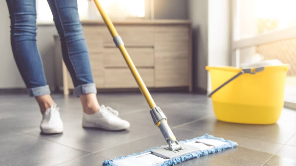 Woman in jeans mopping. 