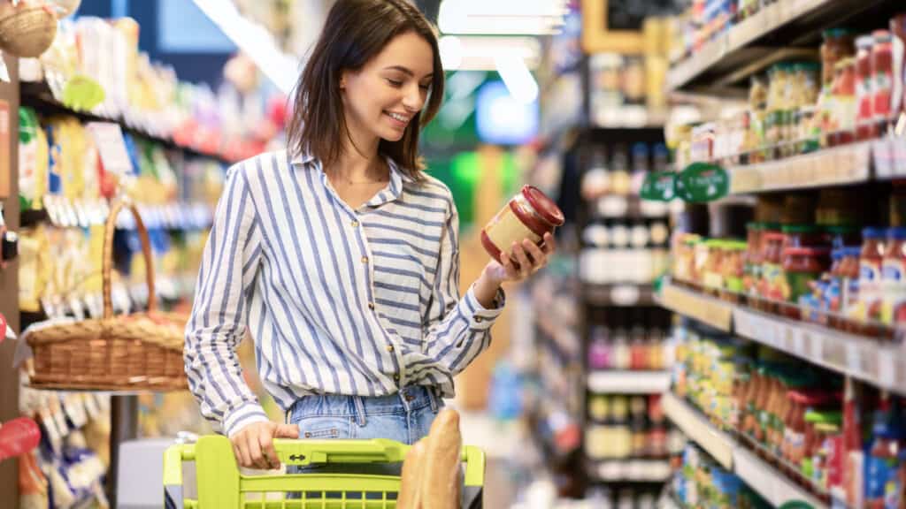 Woman in market looking at product label.