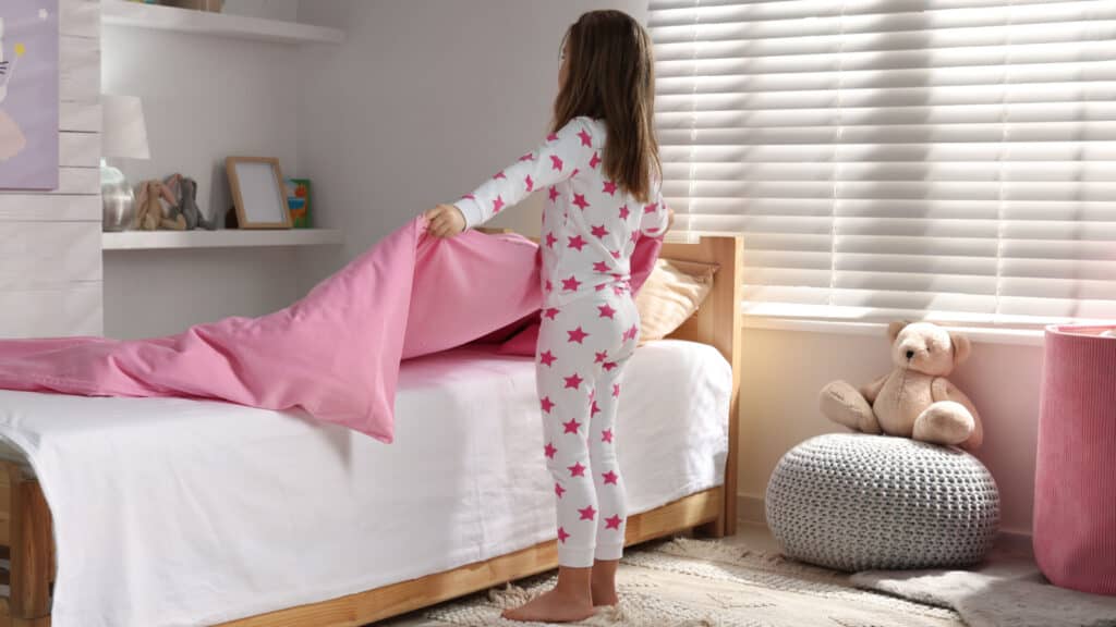 little girl making bed. 