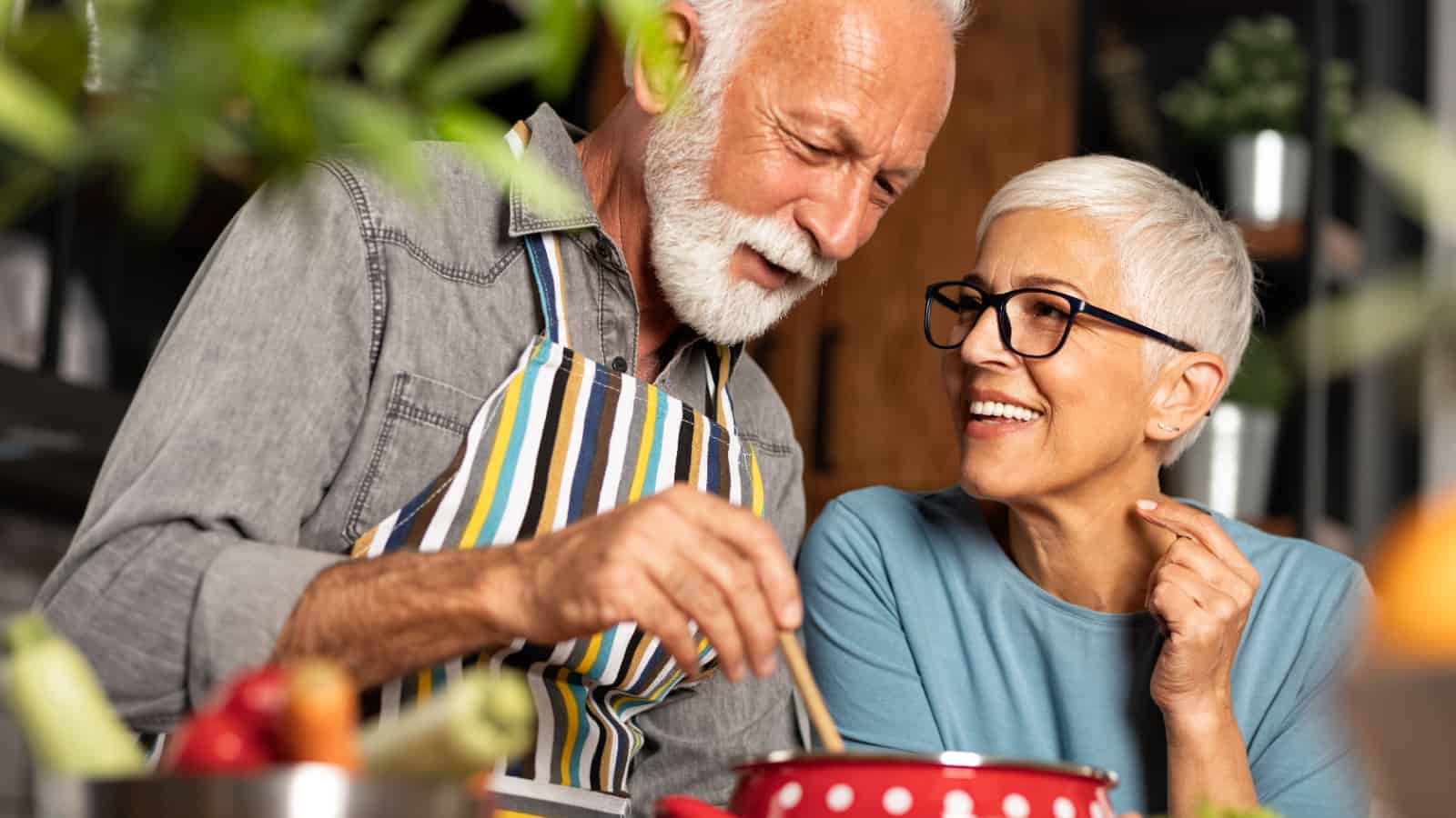 older man and woman cooking together.