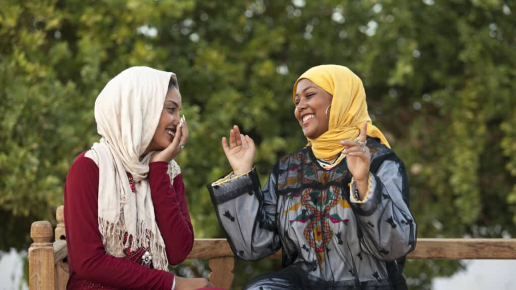two women in head scarves talking. Head covering. two Egyptian girl talking with each.