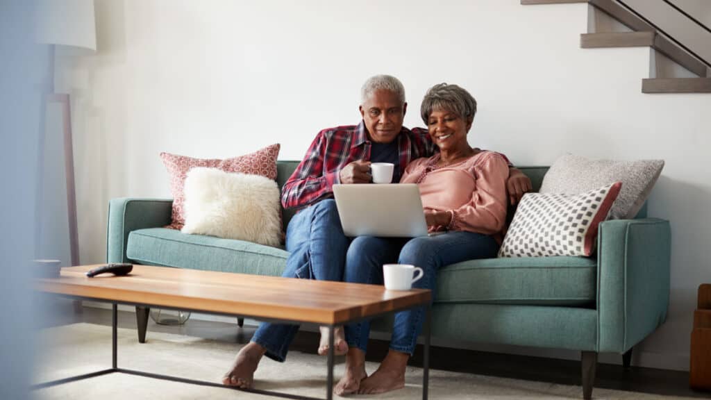 Black couple on couch with computer.