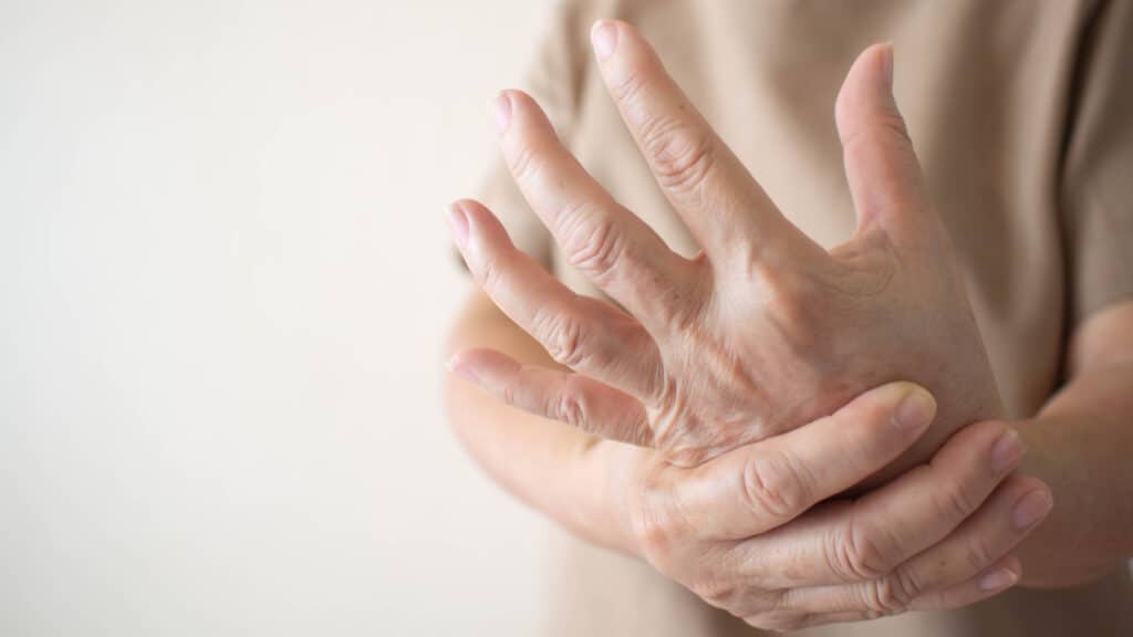 Closeup of woman's hands in pain. Woman clutching other hand. 