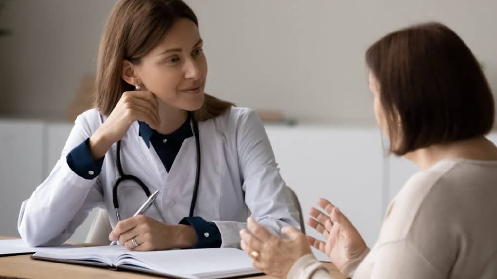Female doctor speaking with older woman patient.