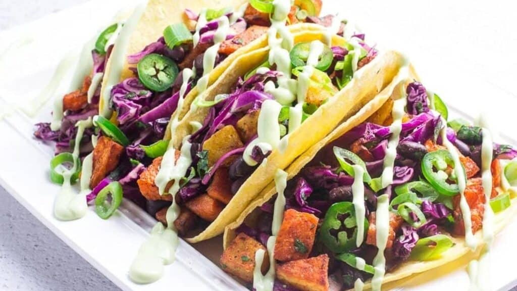 Horizontal-image-of-low-FODMAP-sweet-potato-tacos-with-black-beans-and-Avocado-Lime-Crema.