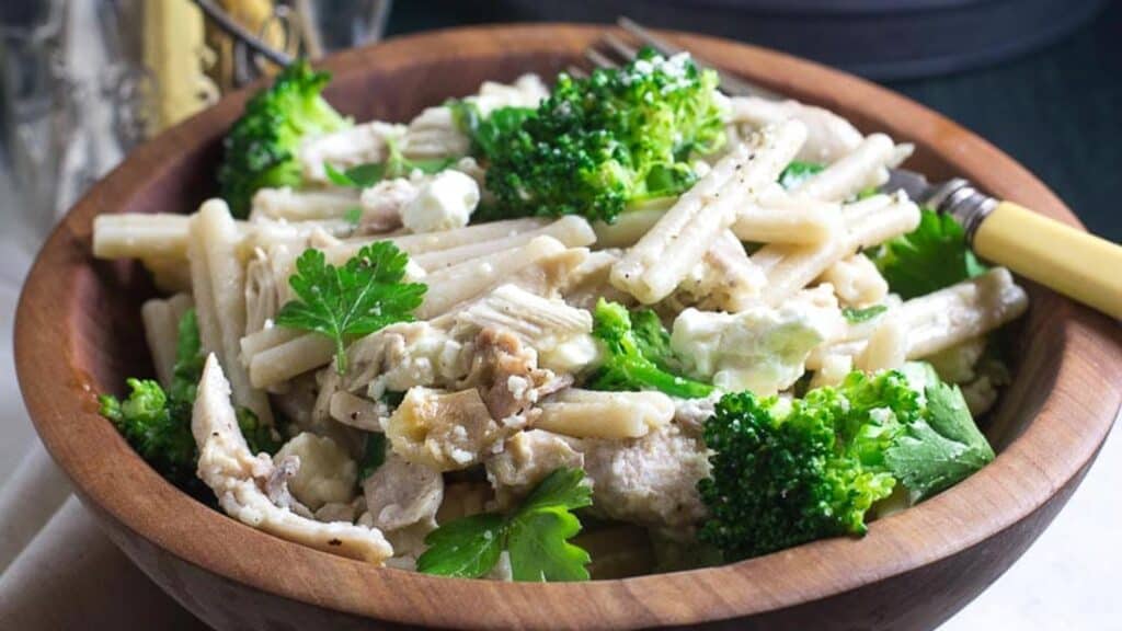 Low-FODMAP-Quick-Pasta-with-Chicken-Broccoli-Goat-Cheese-in-a-wooden-bowl-with-antique-bone-handled-fork.