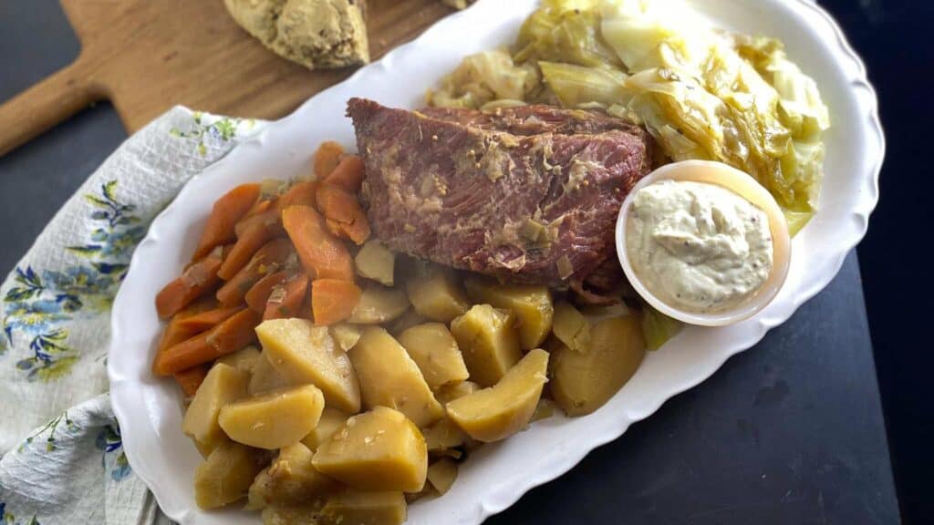 Low-FODMAP-Slow-Cooker-Corned-Beef-on-oval-white-platter-with-cabbage-carrots-and-potatoes-scaled.