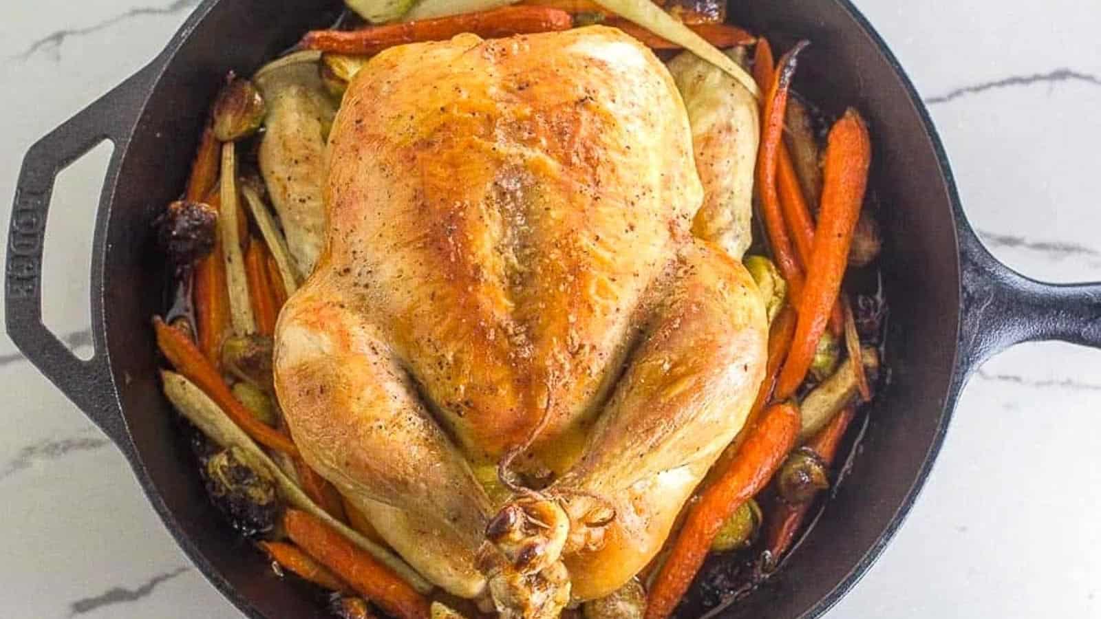 Low-FODMAP-whole-roast-chicken-and-vegetables-in-cast-iron-pan-on-white-quartz.