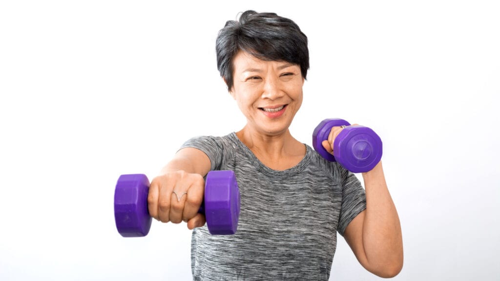 Older Asian woman lifting weights. Exercise.