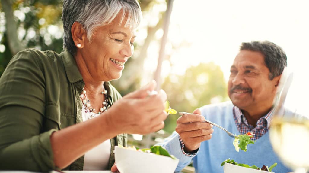 Older couple eating salad.