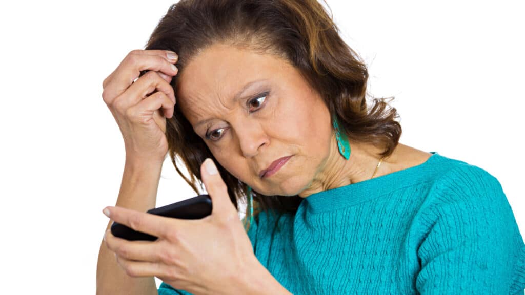 Older woman looking at hair. 