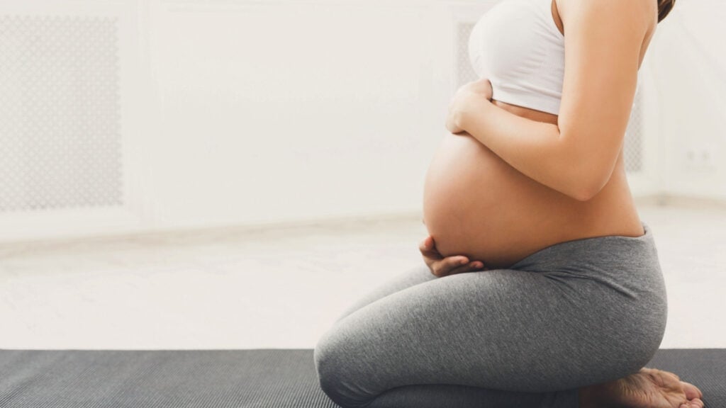 Pregnant woman in kneeling pose.