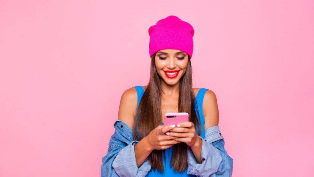 Trendy young woman looking at smartphone.