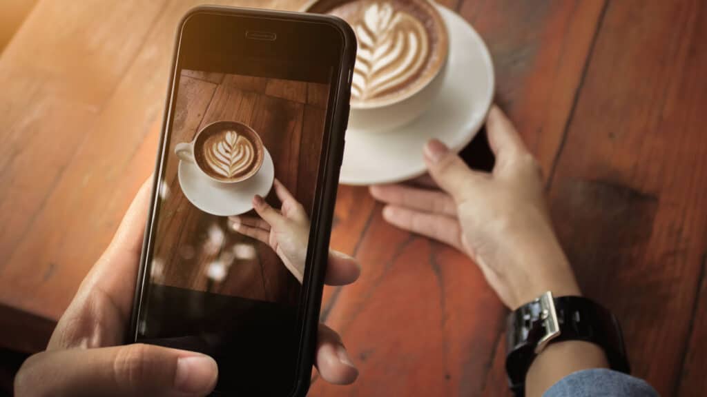 Woman taking picture of coffee art. 