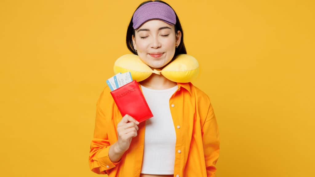 Woman with neck pillow and eye mask. 