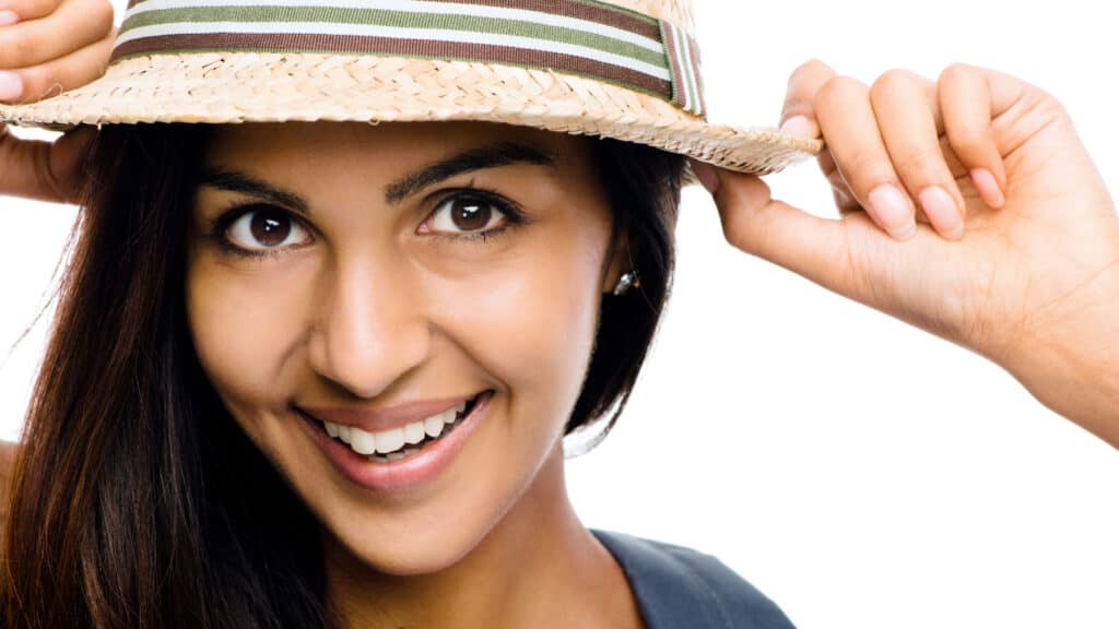 Young woman smiling in hat. 
