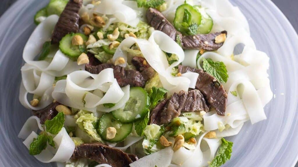 closeup-overhead-of-Asian-Steak-and-Noodle-salad-on-white-plate.