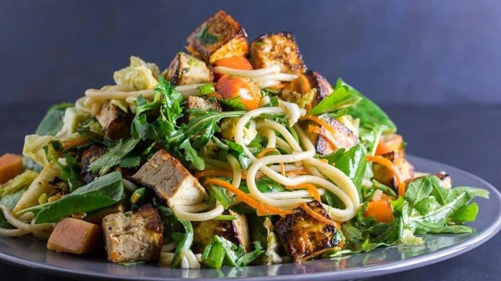 main-image-of-Low-FODMAP-Asian-Tofu-Noodle-Papaya-Salad-on-a-gray-plate-against-dark-background.