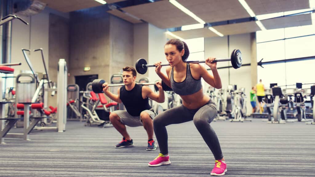 man and woman lifting weights.