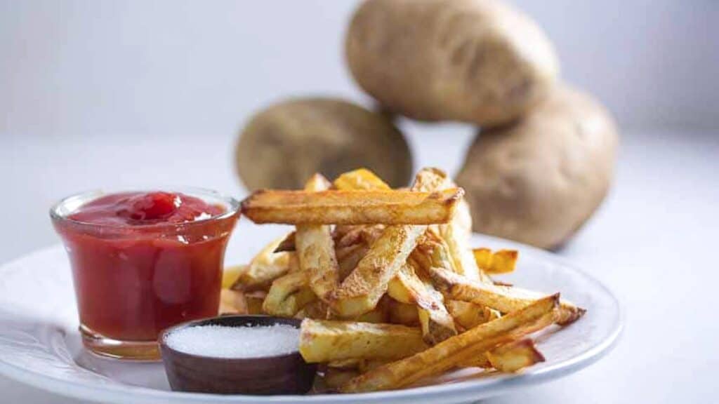 oven-fries-with-potatoes-in-background.
