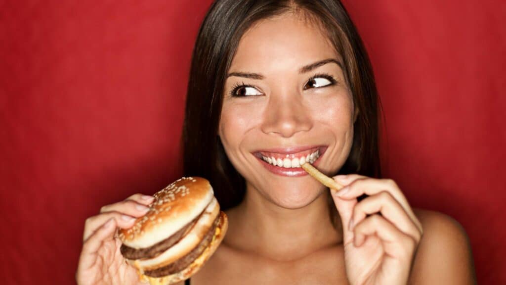 woman eating burger and fries. 