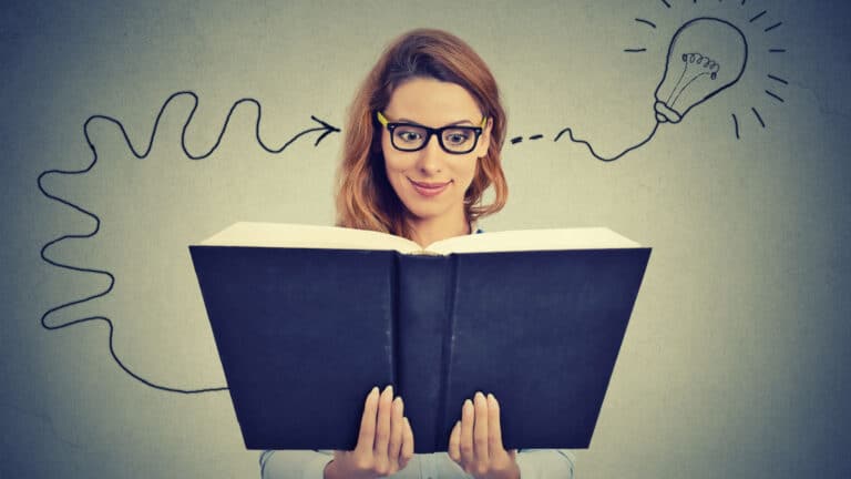 woman reading book. Understanding. Light bulb moment.