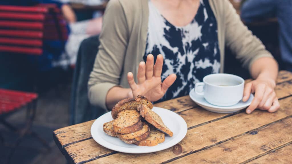 woman saying no to plate of bread.