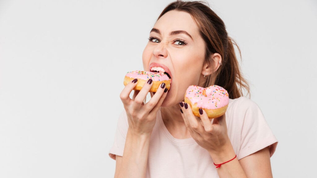 woman stuffing face with donuts. Doughnuts. 