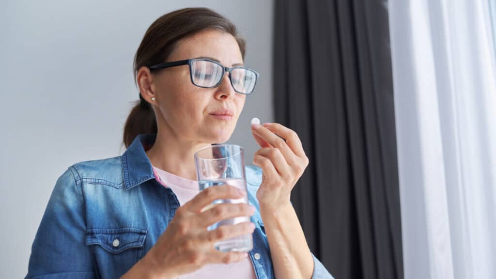 woman taking a pill with water. 