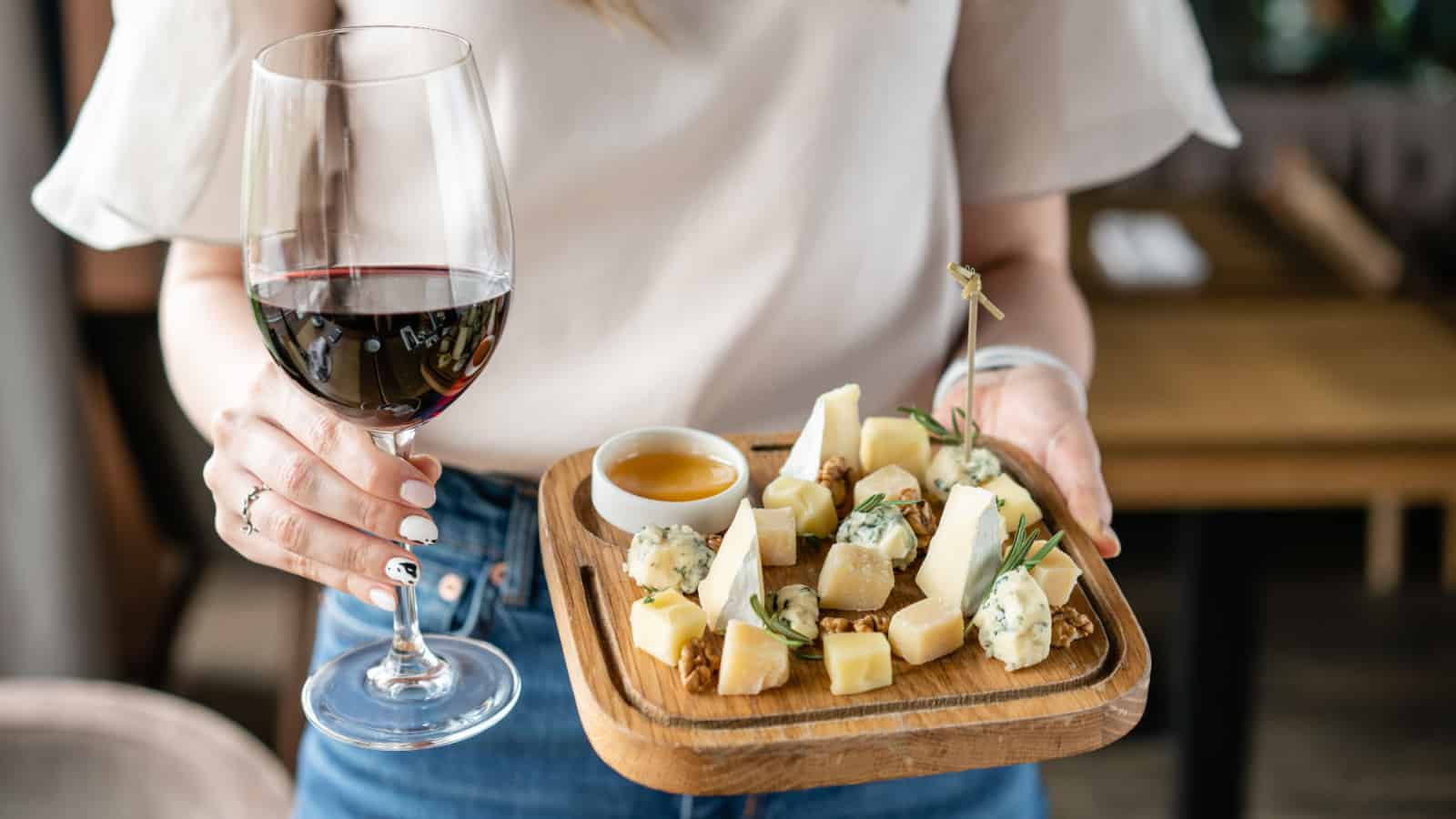 woman with wine and cheese board.