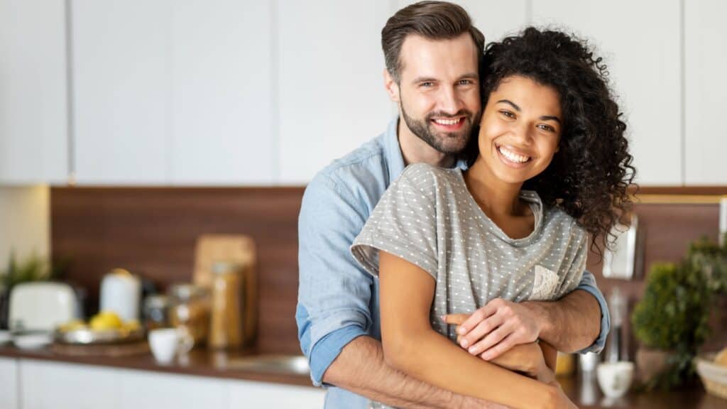 Happy hugging interracial couple.