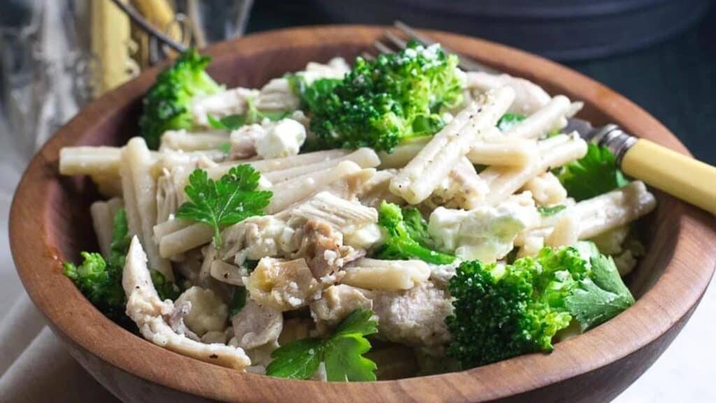 Low-FODMAP-Quick-Pasta-with-Chicken-Broccoli-Goat-Cheese-in-a-wooden-bowl-with-antique-bone-handled-fork.
