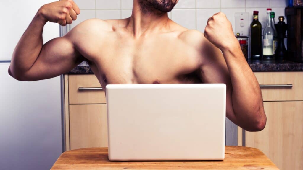 naked man posing on computer laptop