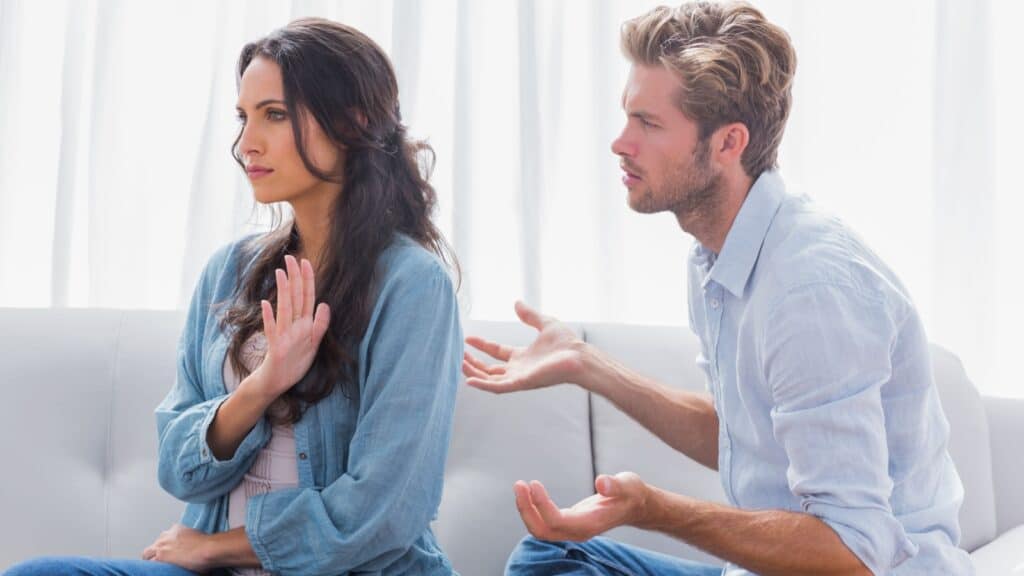 Woman gesturing while quarreling with her partner in the living room