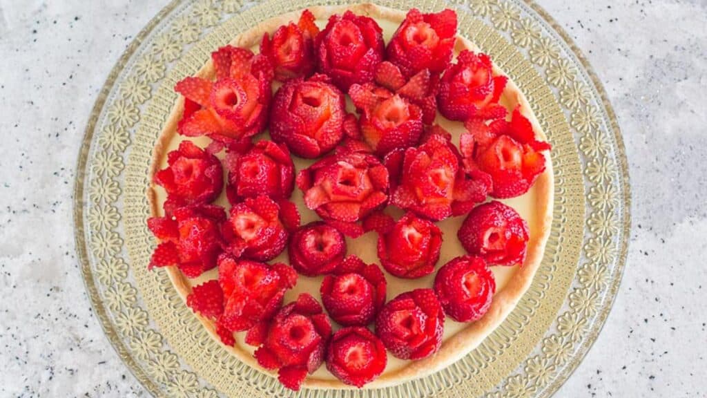 Strawberry-rose-tart-with-pastry-cream-and-tart-crust-on-gold-glass-platter.