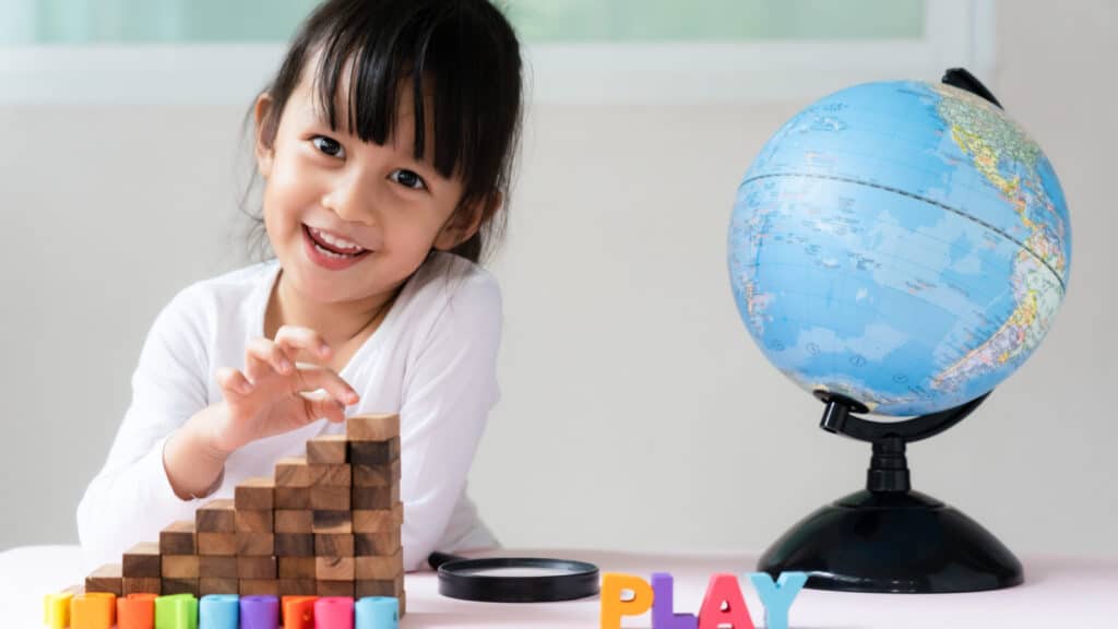 Young Asian girl playing with educational toys. 