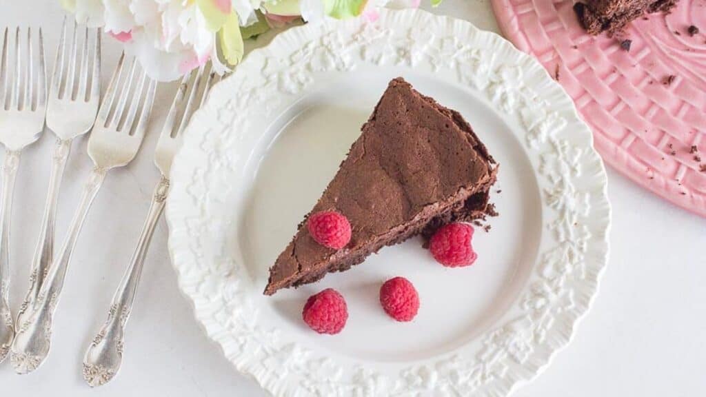 flourless-chocolate-cake-on-a-white-plate-with-fresh-raspberries.