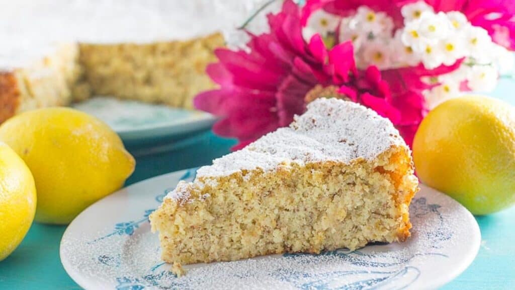 lemon-almond-cake-on-a-blue-and-white-plate-dusted-with-confectioners-sugar.