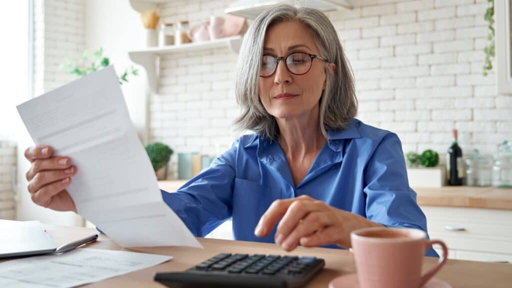 manage debt. Woman with calculator.