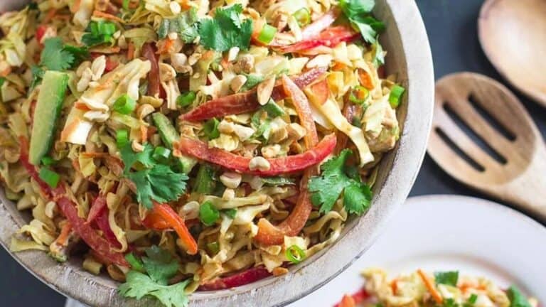 overhead-view-of-Low-FODMAP-Asian-Chicken-Salad-in-wooden-bowl-plate-and-wooden-serving-implements-in-background.